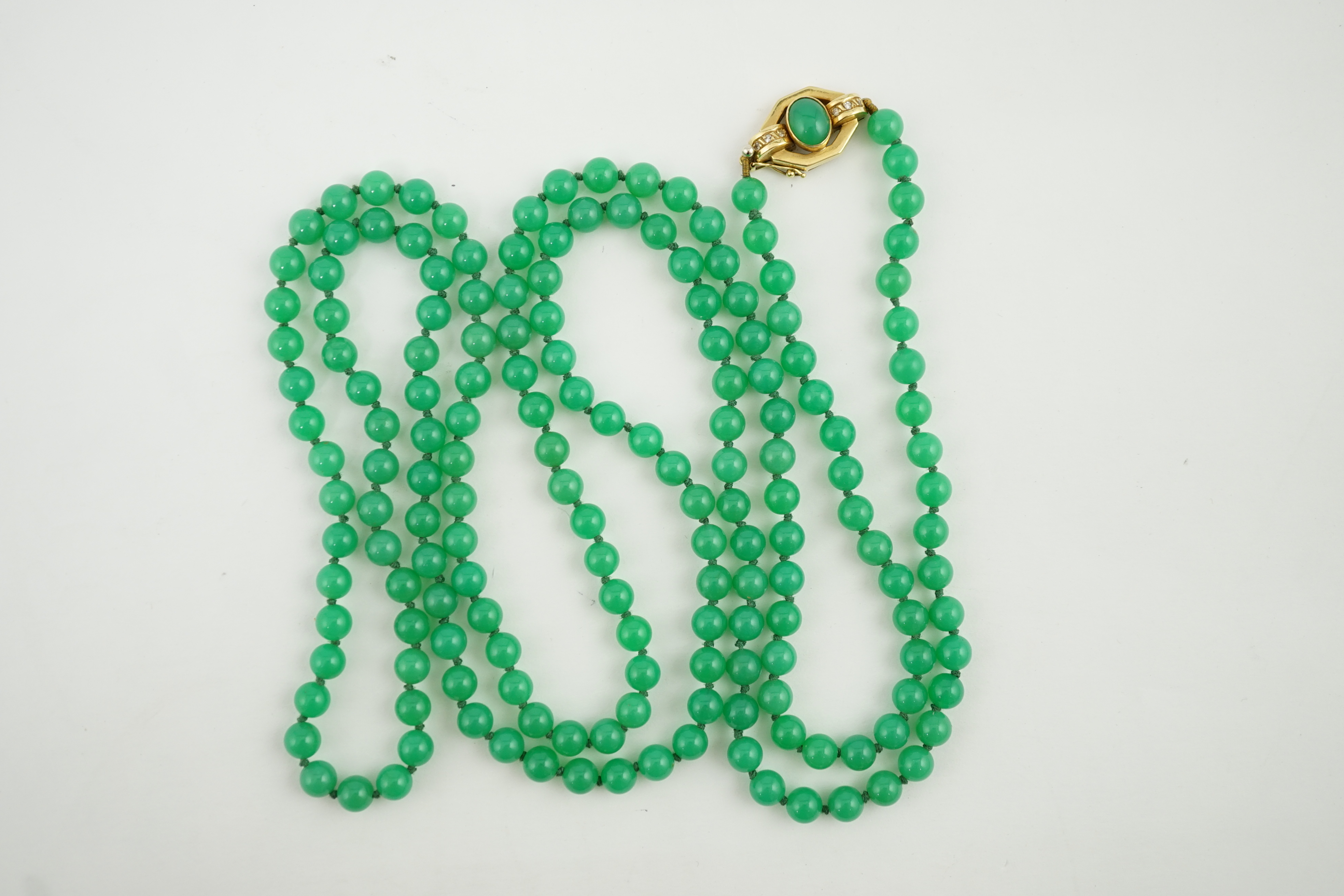 A modern long single strand jadeite bead necklace, with a cabochon jade and diamond chip cluster set 18k clasp